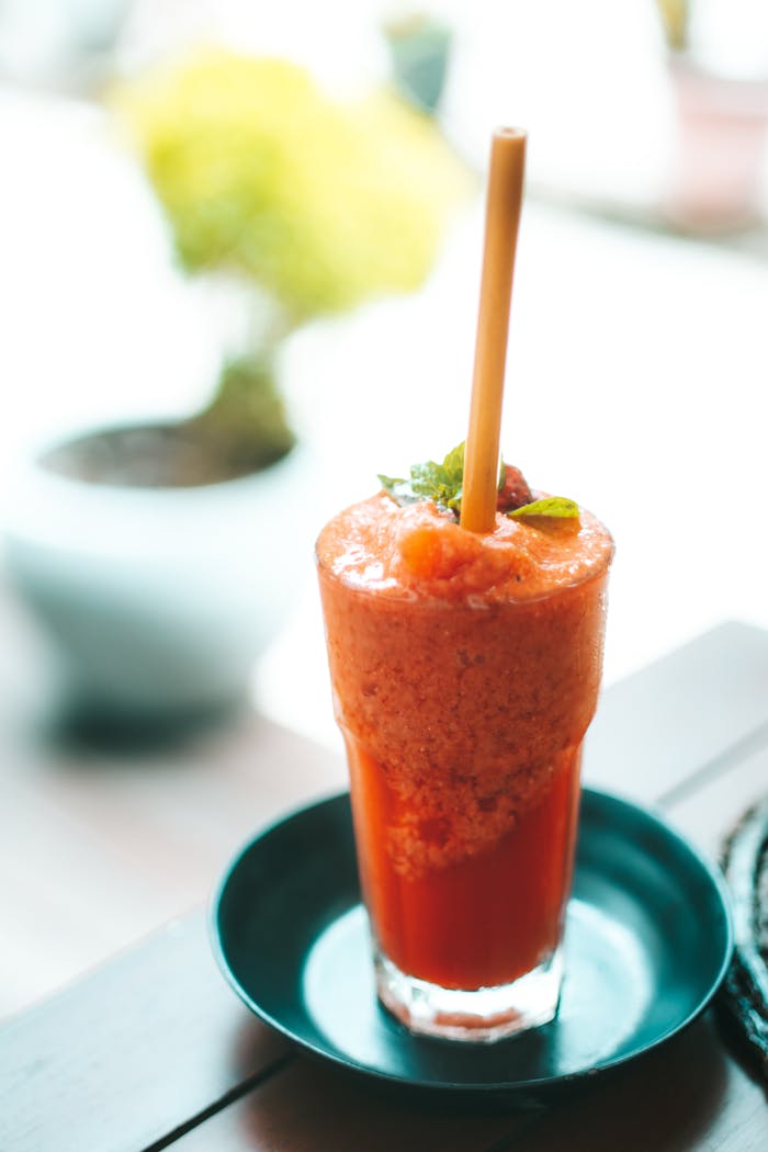A Red Smoothie on Glass Cup with Straw